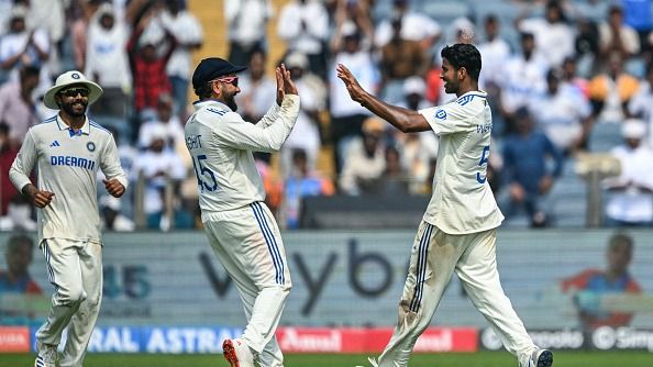 India's Washington Sundar celebrates with his teammates Rohit Sharma (C) and Ravindra Jadeja (L) after taking the wicket