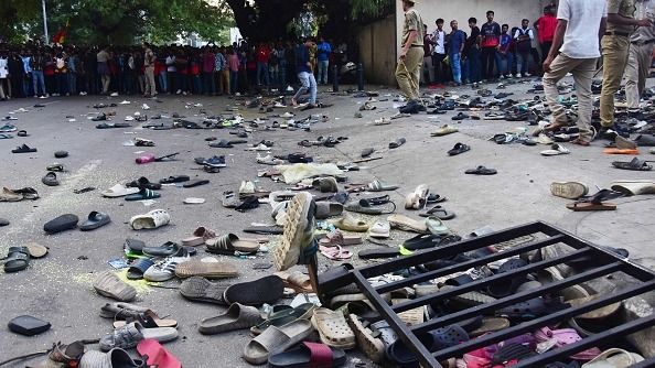 Fans stand next to abandonned shoes and a fallen barrier following a stampede during celebrations