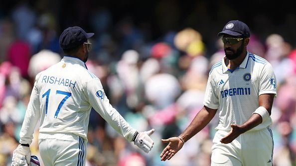 Jasprit Bumrah of India interacts with teammate Rishabh Pant while leaving the field for lunch