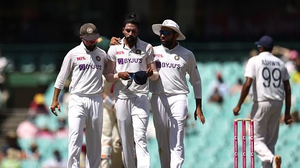 Mohammed Siraj of India is spoken to by Ajinkya Rahane and Rohit Sharma