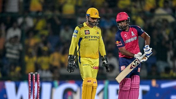 Chennai Super Kings' captain MS Dhoni (L) celebrates after the dismissal of Rajasthan Royals' captain Sanju Samson
