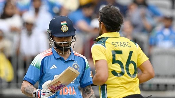 India's Virat Kohli (L) reacts as Australia's paceman Mitchell Starc celebrates his wicket