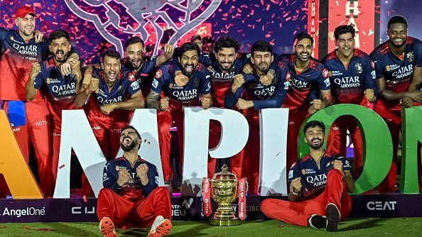 Royal Challengers Bengaluru's Virat Kohli (bottom L), along with his teammates, poses for photographs with the trophy Royal Challengers Bengaluru's Virat Kohli (bottom L), along with his teammates, poses for photographs with the trophy
