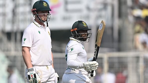 Simon Harmer (L) watches as Temba Bavuma of South Africa raises his bat Simon Harmer (L) watches as Temba Bavuma of South Africa raises his bat