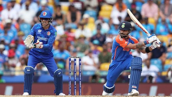 Virat Kohli of India plays a shot as Rahmanullah Gurbaz of Afghanistan keeps