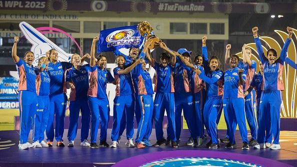 Mumbai Indians players celebrate with the winners trophy after the WPL Final 2025