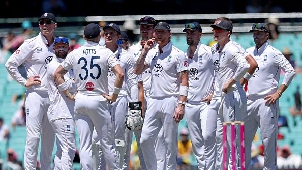 England's captain Ben Stokes (C) reacts with teammates as they watch a replay