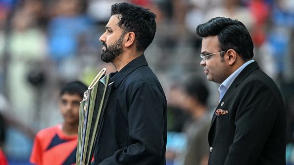 India's cricketer Rohit Sharma (L) holds the 2026 ICC Men's T20 Cricket World Cup trophy