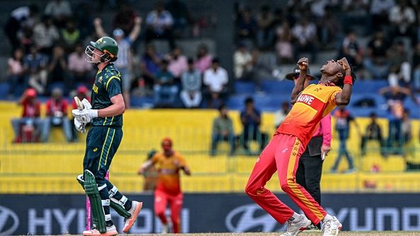 Blessing Muzarabani (R) celebrates after taking the wicket of Australia's Matt Renshaw