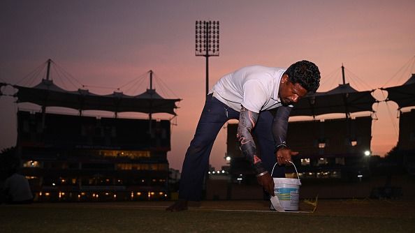 A grounds staff member paints lines on the pitch duringat MA Chidambaram Stadium