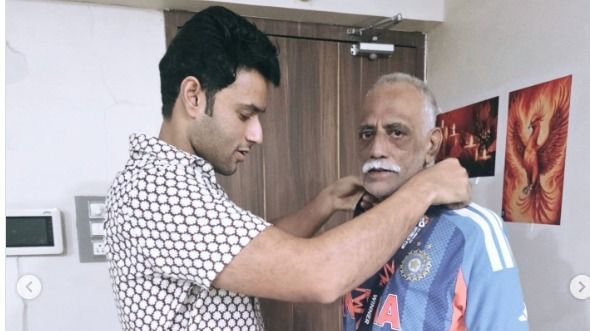 Shivam Dubey presenting the medal to his father