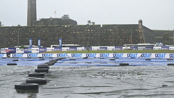 A general view shows covered ground as rain delays the start