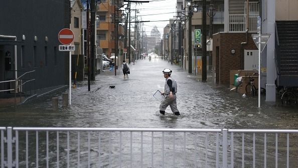 People wade through a flooded street in Nagoya