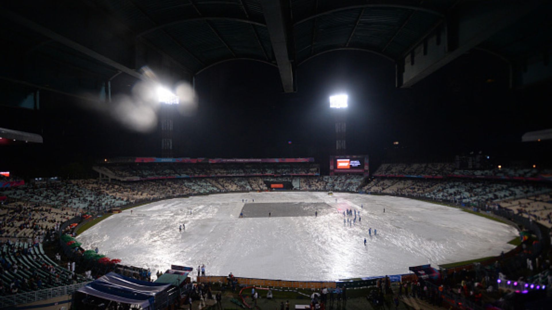 Groundsmen work on covered field to remove rain water ahead of the ICC World Twenty20 2016 cricket match between India and Pakistan at Eden Gardens in Kolkata.