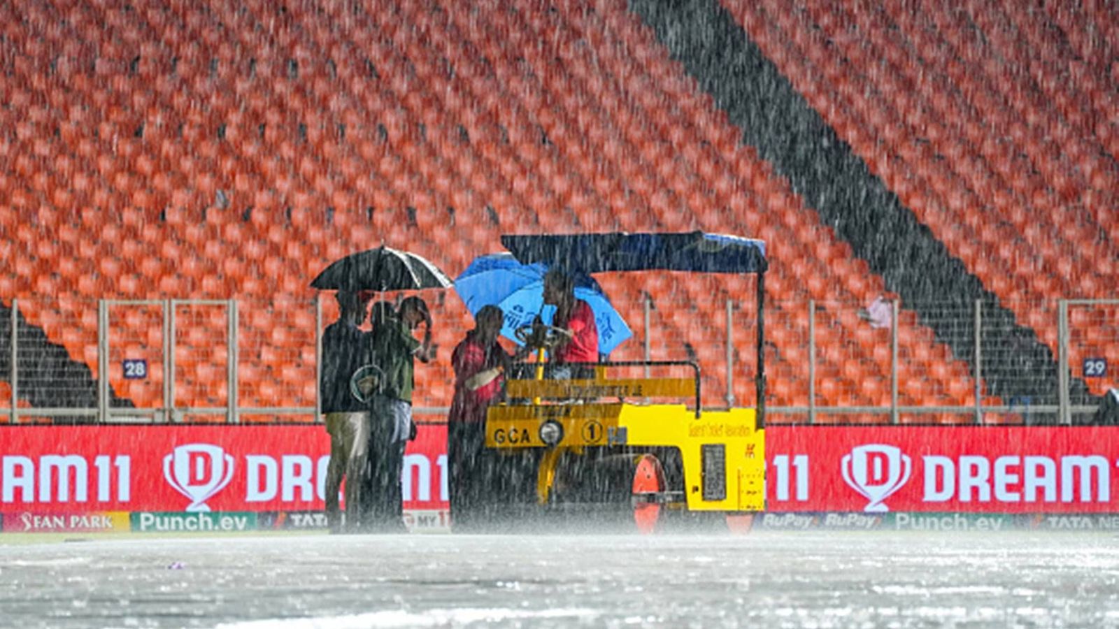 Gujarat Titans knocked out of playoff race as rain plays spoilsport, KKR book Qualifier spot Ground staff take shelter under umbrellas at Narendra Modi Stadium, Ahmedabad (Getty Images)