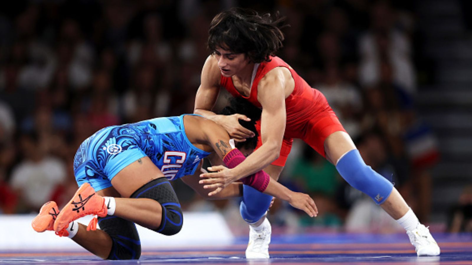 Paris Olympics: Vinesh Phogat scripts history, assures India 1st medal in wrestling with stunning win over Yusneylis Guzman to storm into final India's Vinesh Vinesh (red) competes with Yusneylis Guzman Lopez of Team Cuba (blue) during the Wrestling Women's Freestyle 50kg Semifinal at the Paris Olympics on August 06. (Getty)