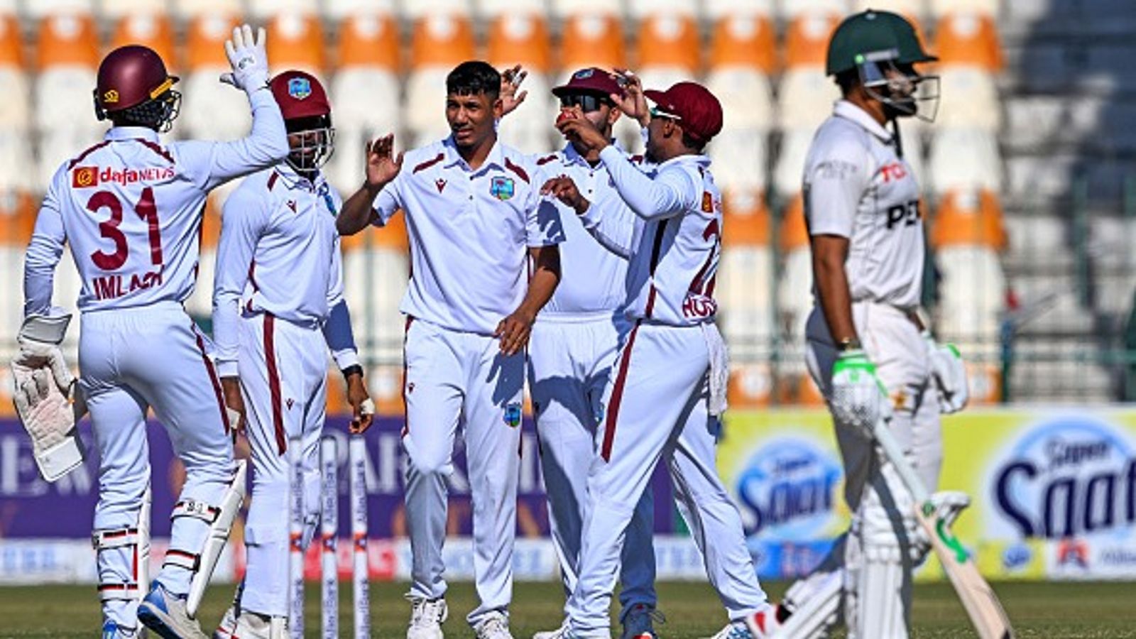 PAK vs WI, 2nd Test: Warrican-Motie's spin sorcery helps West Indies bulldoze Pakistan for 154 in a strong retort on Day 1 West Indies' players celebrate as Pakistan's Babar Azam (R) walks back to the pavilion after his dismissal during on Day 1 of the 2nd Test