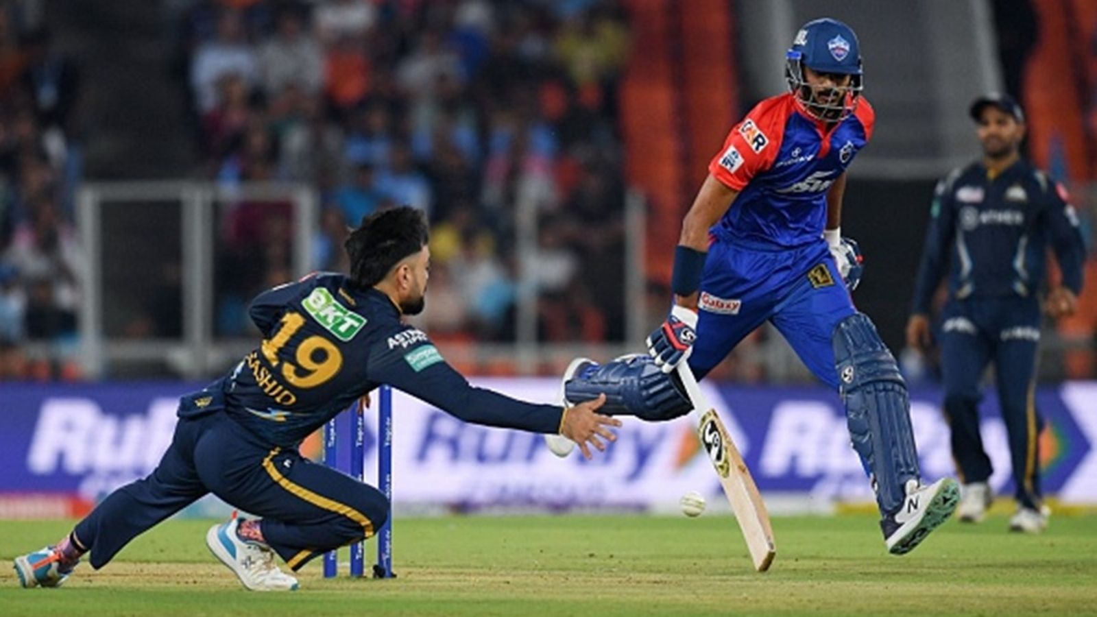 GT vs DC Match Prediction: Gujarat Titans face their biggest challenge at home as Axar Patel's Delhi Capitals look to continue dominant run Gujarat Titans' Rashid Khan (L) dives to field the ball as Delhi Capitals' Axar Patel runs to save his wicket during the Indian Premier League (IPL) match at the Narendra Modi Stadium in Ahmedabad on May 2, 2023.