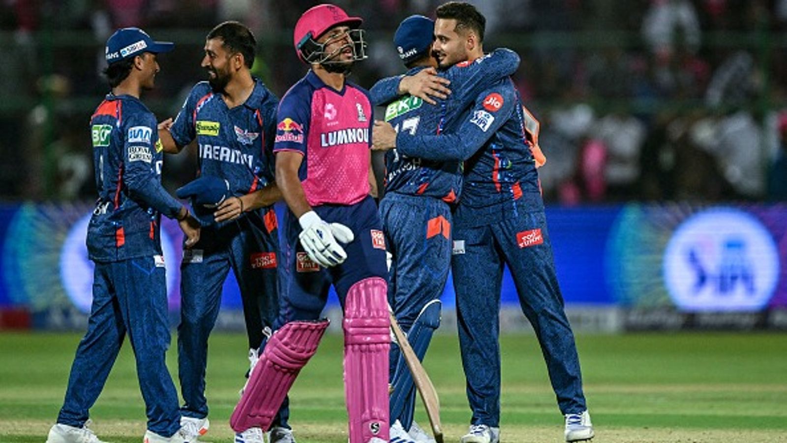 'It's been hard, but...': RR coach Sairaj Bahutule's big 'dressing room' revelation after team's narrow loss to LSG Dhruv Jurel (C) looks on as Lucknow Super Giants' players (back) celebrate after their team's win in the Indian Premier League (IPL) Twenty20 cricket match between Rajasthan Royals and Lucknow Super Giants