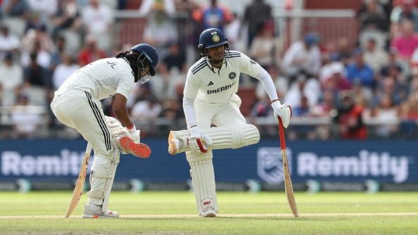 Shubman Gill and KL Rahul of India stretch between overs during day four of the 4th Rothesay Test Match between England and India at Emirates Old Trafford on July 26, 2025 in Manchester, England.