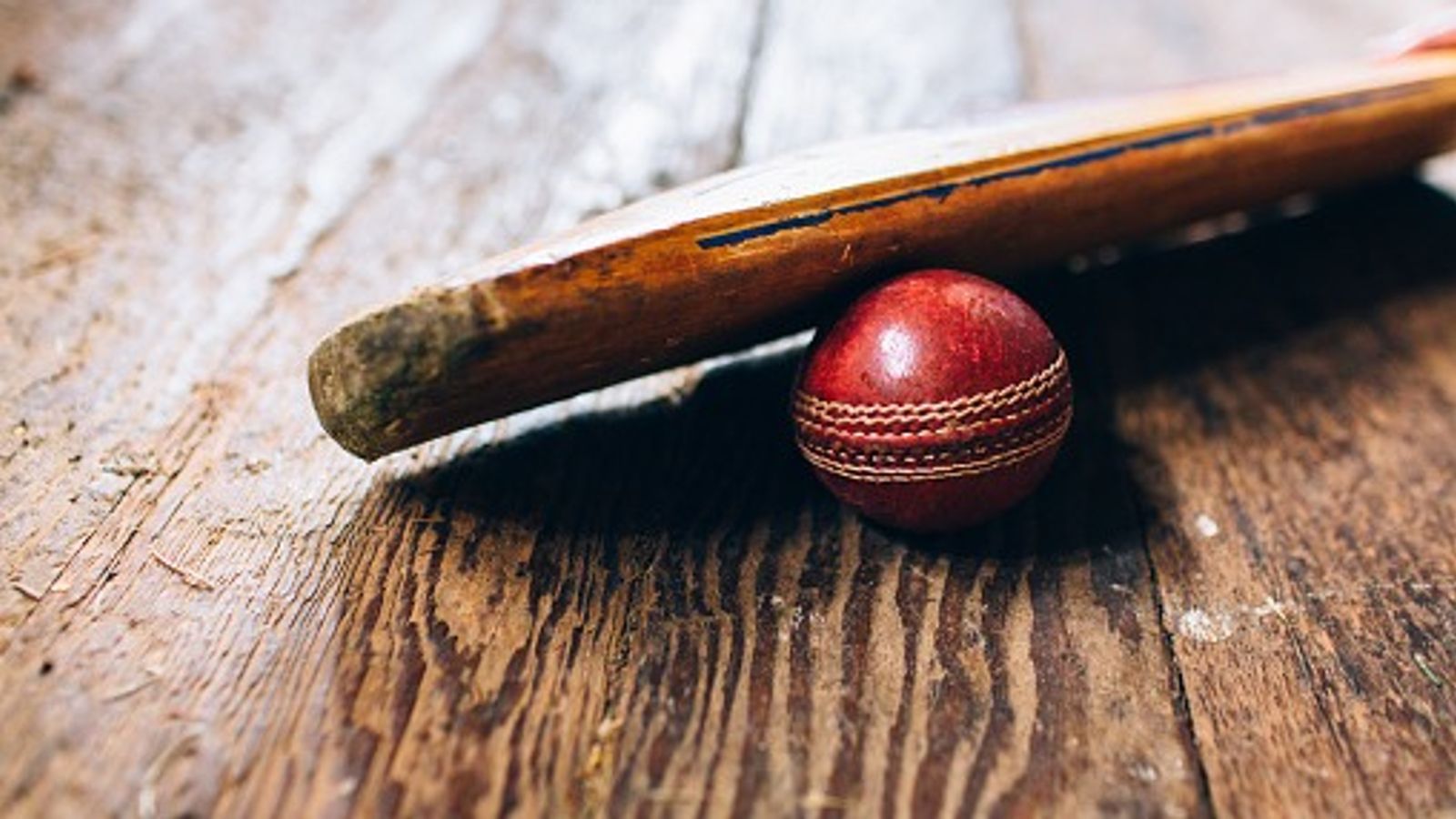 ICC hands five-year ban to former Sri Lankan cricketer over match-fixing in this league A cricket bat resting on a red cricket ball on a wooden floor in this frame