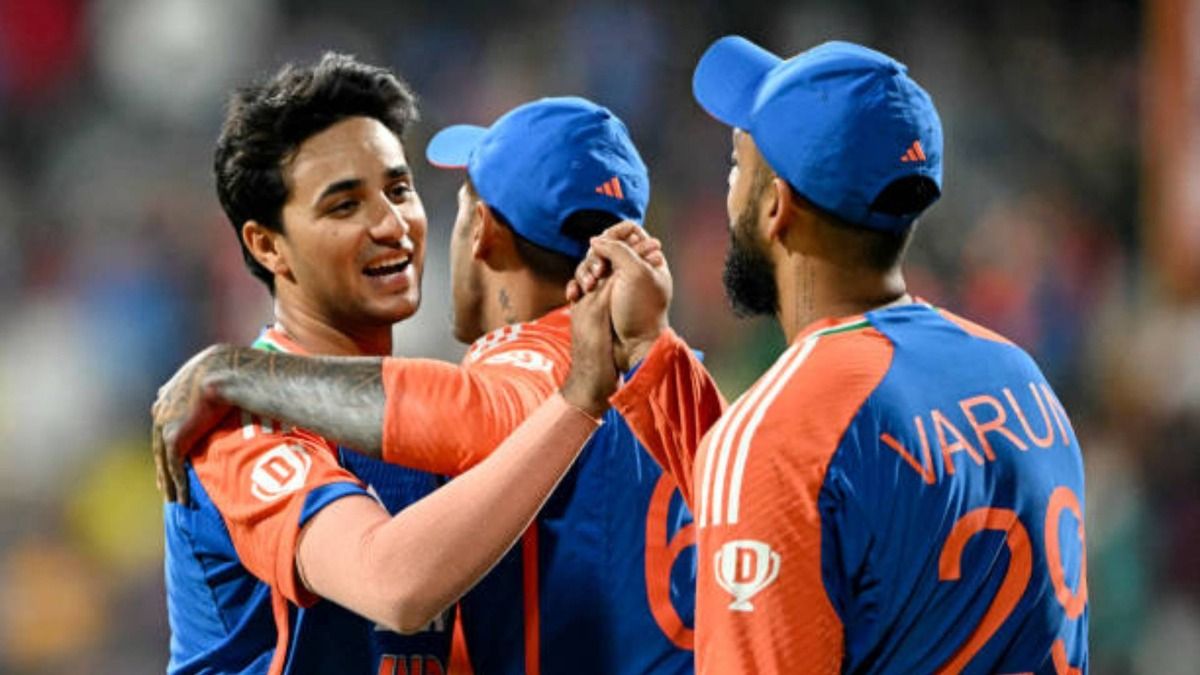 India's Abhishek Sharma (L) and Varun Chakravarthy (R) celebrate with teammate after taking the wicket of England's Brydon Carse during the fifth and final Twenty20 international cricket match between India and England