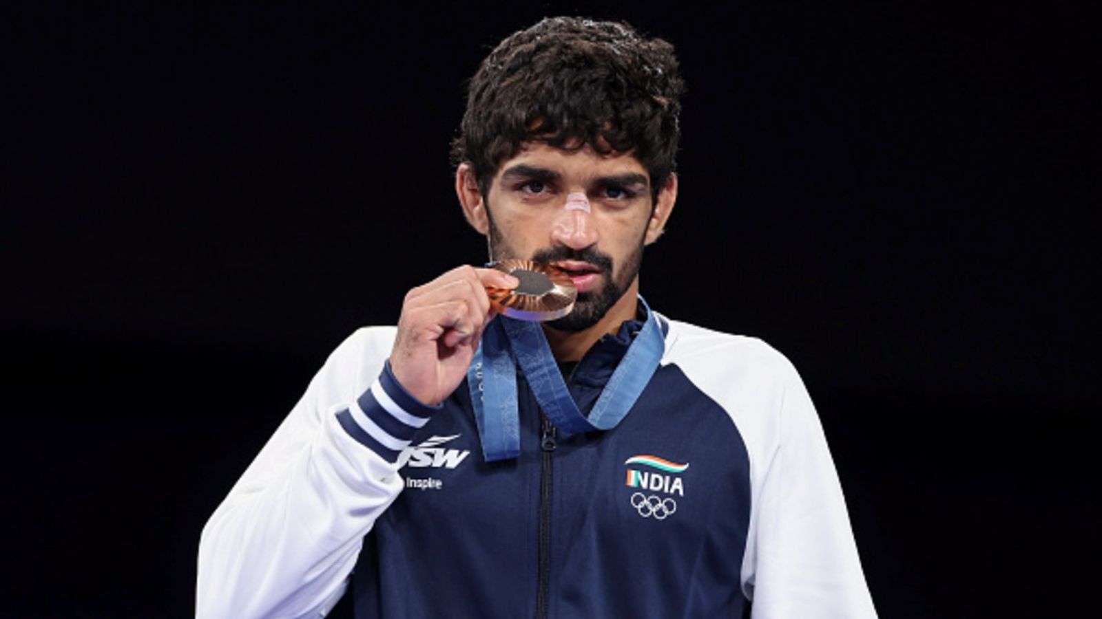 WFI hands 1-year suspension to Paris Olympics bronze medallist Aman Sehrawat for being 1.7 kg overweight at World Championships Bronze medallist Aman Sehrawat stands on the podium during the Wrestling Men's Freestyle 57kg medal ceremony on day 14 of the Olympic Games Paris 2024 at Champs-de-Mars Arena on August 09, 2024 in Paris, France.