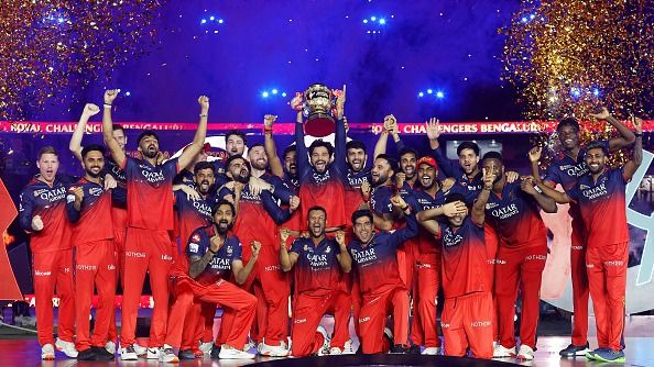 RCB captain Rajat Patidar lifts the IPL 2025 trophy alongside teammates in this frame RCB captain Rajat Patidar lifts the IPL 2025 trophy alongside teammates in this frame