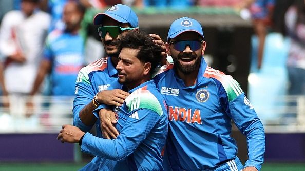 Kuldeep Yadav (C) celebrates with teammates Virat Kohli (R) and Axar Patel after taking the wicket of New Zealand's Kane Williamson during the ICC Champions Trophy one-day international (ODI) final 