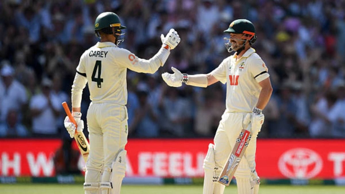 Travis Head (R) celebrates with Alex Carey after reaching his century during day three of the Third Test Match in the 2025-26 Ashes Series between Australia and England (via Getty)