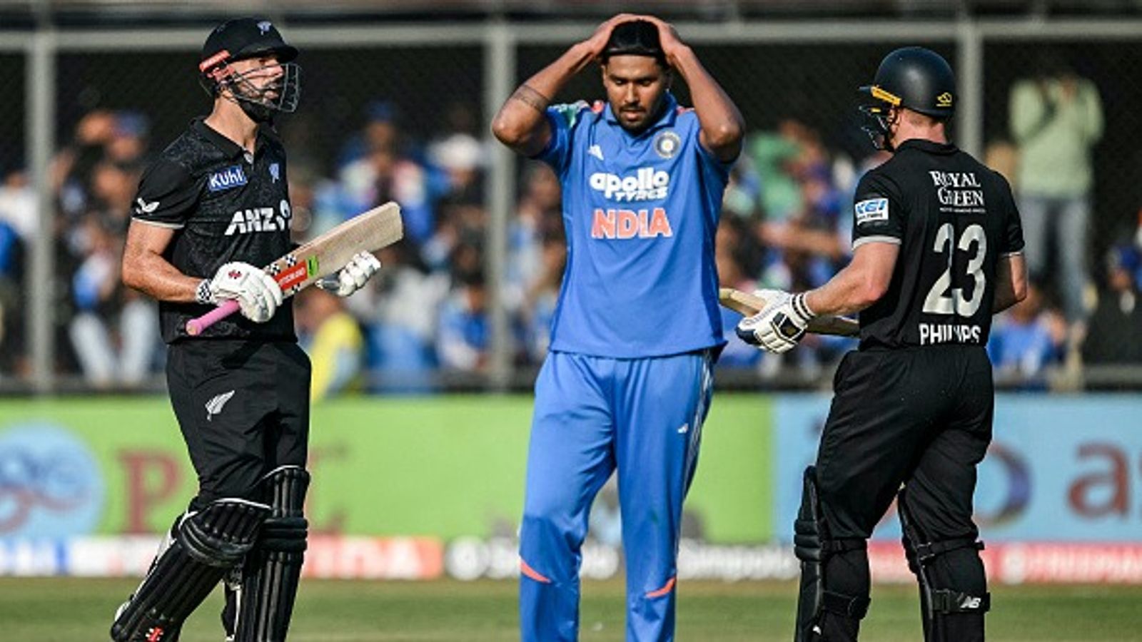 Sunil Gavaskar conducts brutal postmortem of India’s ODI series loss vs New Zealand Harshit Rana (C) reacts as New Zealand's Daryl Mitchell (L) speaks with his teammate Glenn Phillips after hitting a boundry during the third one-day international (ODI) cricket match between India and New Zealand (Getty)