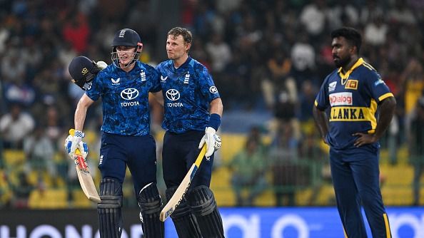 England's captain Harry Brook (L) celebrates after scoring a century (100 runs) with Joe Root (C) during the third one-day international (ODI) cricket match between Sri Lanka and England
