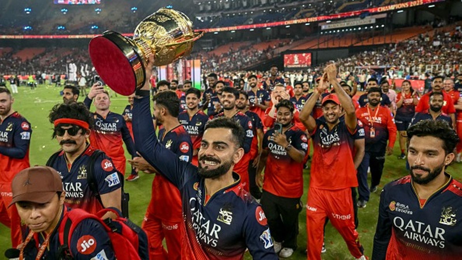 Royal Challengers Bengaluru set for MASSIVE ₹16,700 crore takeover ahead of IPL 2026 Royal Challengers Bengaluru's Virat Kohli (C), along with his teammates, takes a victory lap around the field as he celebrates with the trophy after winning the Indian Premier League (IPL) Twenty20 final cricket match against Punjab Kings (Getty)