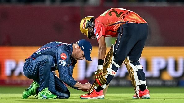 Former LSG batter David Miller (L) ties the shoelaces of Punjab Kings' Shashank Singh in this frame. (Getty)