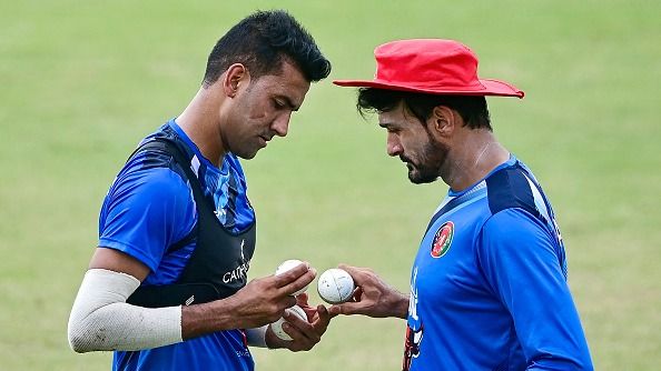 Afghanistan's Mohammad Saleem (L) talks to bowling coach Hamid Hassan during a practice session in this frame. (Getty)