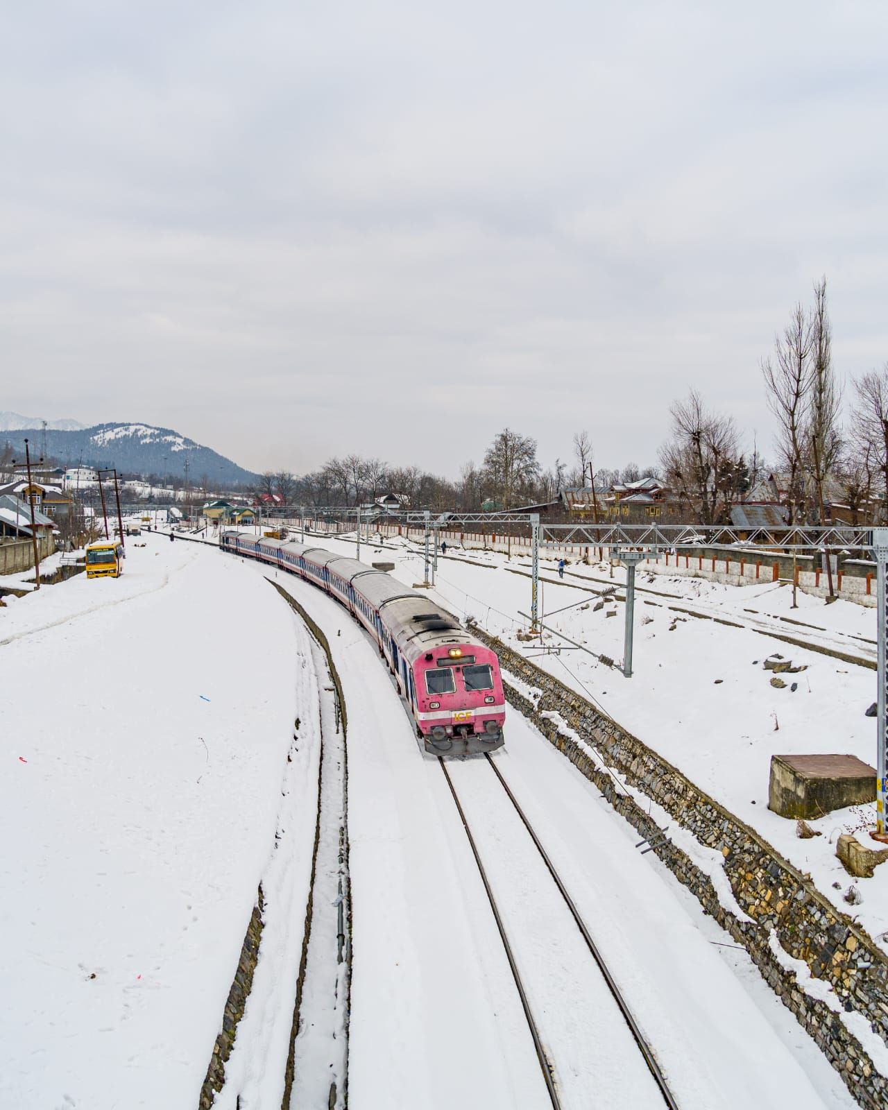 A pink train on a snowy railroad