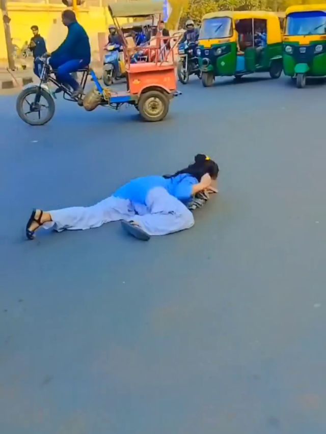 बीच सड़क पर फेंका बैग, स्कूल ड्रेस में लेट लेटकर नाची लड़की- VIDEO